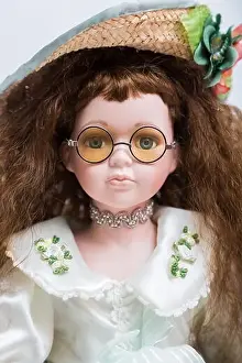 Portrait of a ceramic porcelain handmade vintage doll with yellow glasses