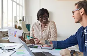 Coworker Prints: Portrait of two IT developers smiling while designing interface for mobile application or website