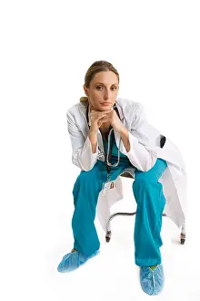 Knees Prints: portrait of female doctor leaning on knees sitting in scrubs and lab coat