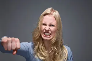 Long Haired Prints: Portrait of furious young woman with outstretched fist and bared teeth