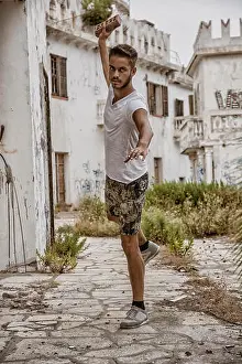 Throw Prints: Portrait of good-looking man holding brick up in hand ready to throw it at camera
