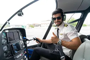 Cockpit Prints: Portrait of handsome commercial pilot in captain white uniform with headset sitting and thumb up