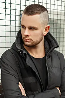 Hood Prints: Portrait of a handsome serious man with a short hairstyle in a winter stylish jacket in the street