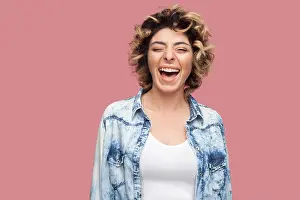 Careless Prints: Portrait of happy laughter young woman with curly hairstyle in casual blue shirt standing