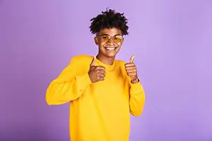 Sweatshirt Prints: Portrait of a happy young afro american man in sweatshirt isolated, showing thumbs up