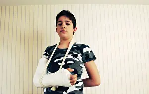 Youngster Prints: portrait of a Kid with a broken arm looking at camera
