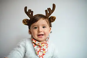Antlers Prints: Portrait of laughing baby girl with reindeer antlers headband