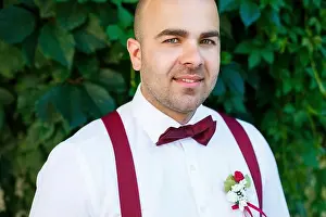 Adjusting Prints: Portrait of a man groom with a red bow-tie and suspenders