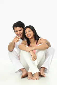 Young Couple Prints: Portrait of a man pointing and smiling with his wife