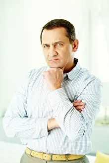 Crossed Prints: Portrait of mature man with crossed arms touching his chin