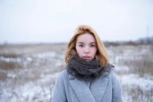 Beautiful Woman Prints: Portrait of young woman standing in snowy landscape