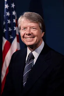 Elect Prints: Portrait of President Jimmy Carter in dark suit with US flag in background. (1977)