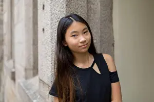 Self Assured Prints: Portrait of a preteen girl leaning against a stone wall; Hong Kong, China