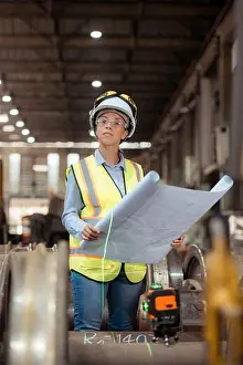 Vest Prints: Portrait of railway technician worker in safety vest and helmet working with blueprint at train repair station