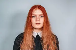 Redhead Prints: Portrait of serious red-haired girl in black dress with white collar