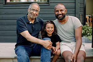Love Emotion Prints: Portrait of smiling boy sitting with father and grandfather on porch