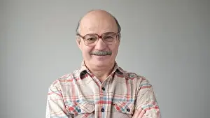 Business Man Prints: Portrait of smiling mature man wearing glasses standing on white background