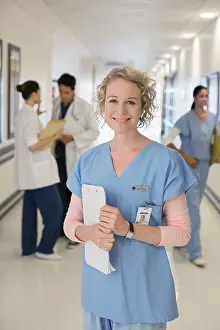 Three Quarter Length Prints: Portrait of smiling nurse in hospital corridor
