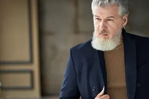 Middle Aged Prints: Portrait of stylish handsome mature man in casual clothes looking away while posing indoors
