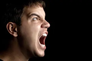 portrait of young angry man sreaming isolated on black background