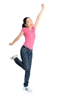 Fullbody Prints: Portrait of young Asian girl in pink shirt and jeans jumping happily
