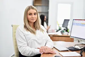 Office Worker Prints: Portrait of a young blonde woman in the office at her workplace