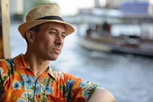 Partial View Prints: Portrait of young handsome tourist man riding boat as public transportation in Bangkok city