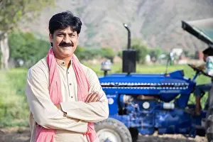 Male Portrait Prints: Portrait of young happy indian farmer standing with blue tractor at agriculture field