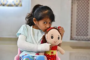 Playtime Prints: Portrait of a young Indian girl with a broken hand in plaster