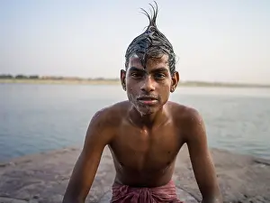 Banks Prints: Portrait of young Indian man washing his hair in the Ganges River ( Varanasi )