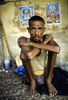 Arms Crossed Prints: Portrait of an young man with Aids in his home in Mumbai, India