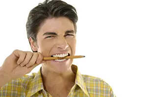 Making A Face Prints: Portrait of a young man biting a pencil with his teeth