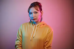 Lgbt Prints: Portrait of serious young transgender woman in yellow hoodie