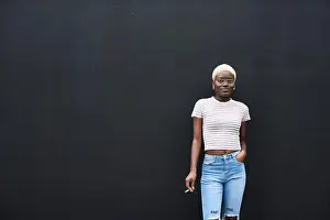 Young Adults Prints: Portrait of young woman with cigarette in front of black background