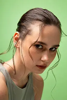 Fashion Model Prints: Portrait of young woman with gathered dark hair with plump lips isolated on green