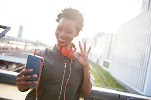 Selfie Prints: Portrait of young woman with headphones taking selfie with smartphone