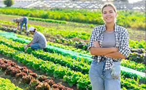 Resting Prints: Positive woman owner of plantation garden is resting standing after work and tasks