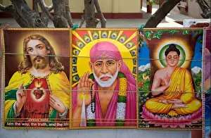 Posters of Jesus Christ, Shirdi Sai Baba and Lord Buddha Shakyamuni together on a stall in Sarnath, Uttar Pradesh, India