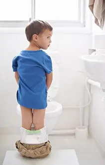 Diaper Prints: Potty training. Rearview shot of a young boy going to the bathroom