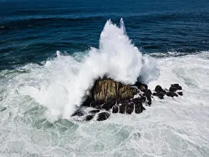 Powerful swells from the Pacific Ocean crash against the rocks just off the coastline of the Monterey peninsula in California