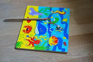 Woodwork Prints: POZNAN, POLAND - Mar 07, 2016: A colorful wooden magnetic fishing puzzle with sea animal illustrations