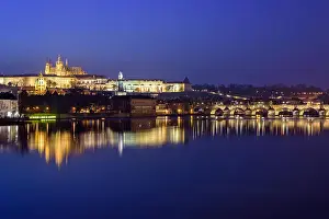 Vltava Prints: Prague Castle and Charles Bridge at night blue hour with lights glowing and reflecting on water
