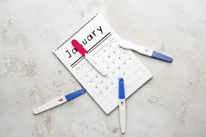 Parenthood Prints: Pregnancy tests and calendar on light background