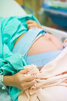 Examine Prints: pregnant female feeling the pain of contraction labor in hospital