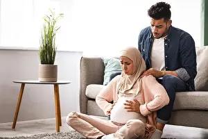 Comforting Prints: Pregnant muslim lady suffering prenatal contractions at home