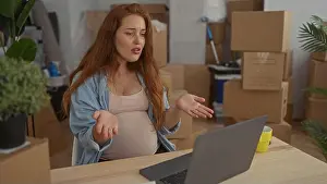Belly Prints: Pregnant woman shrugs hands over exposed belly in a new home surrounded by unpacked boxes; uncertainty transition