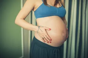 Sisters Prints: A pregnant woman in workout clothes is touching her belly