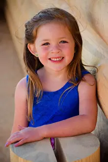 Blond Hair Prints: Pretty 4 year old girl in colorful blue dress on log cabin