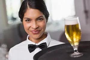 Well Dressed Prints: Pretty waitress holding tray with glass of beer in a fancy restaurant