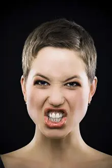 Single Person Prints: Pretty woman with short hair pulling faces in front of a black background